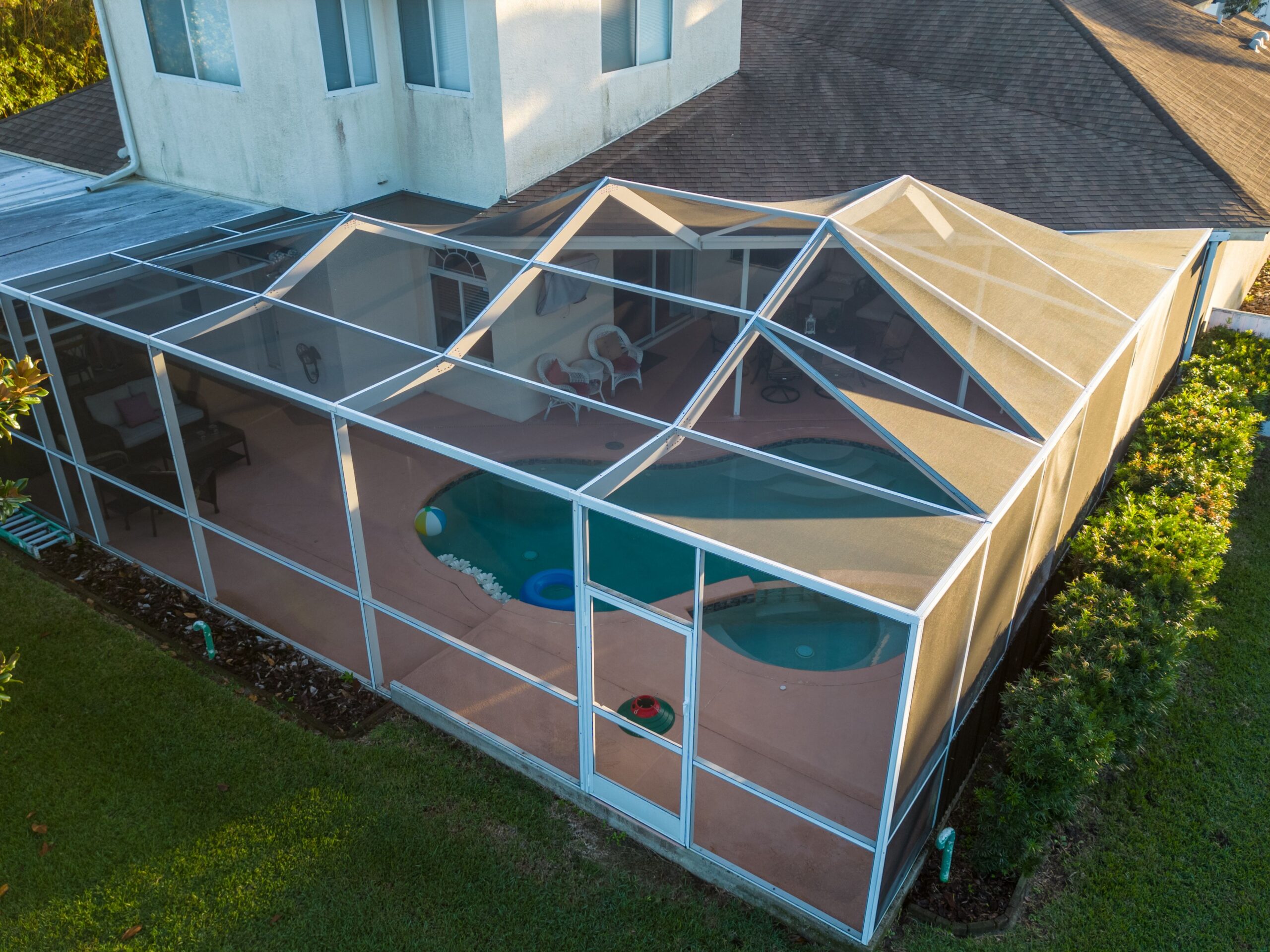 Aerial view of pool screen enclosure surrounded by trees An aerial view of pool screen enclosure surrounded by trees